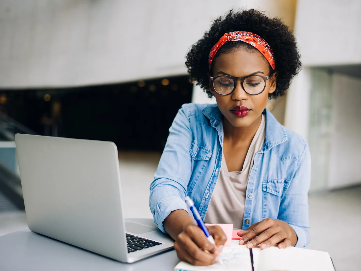 Professional reviewing notes and planning next steps at a laptop