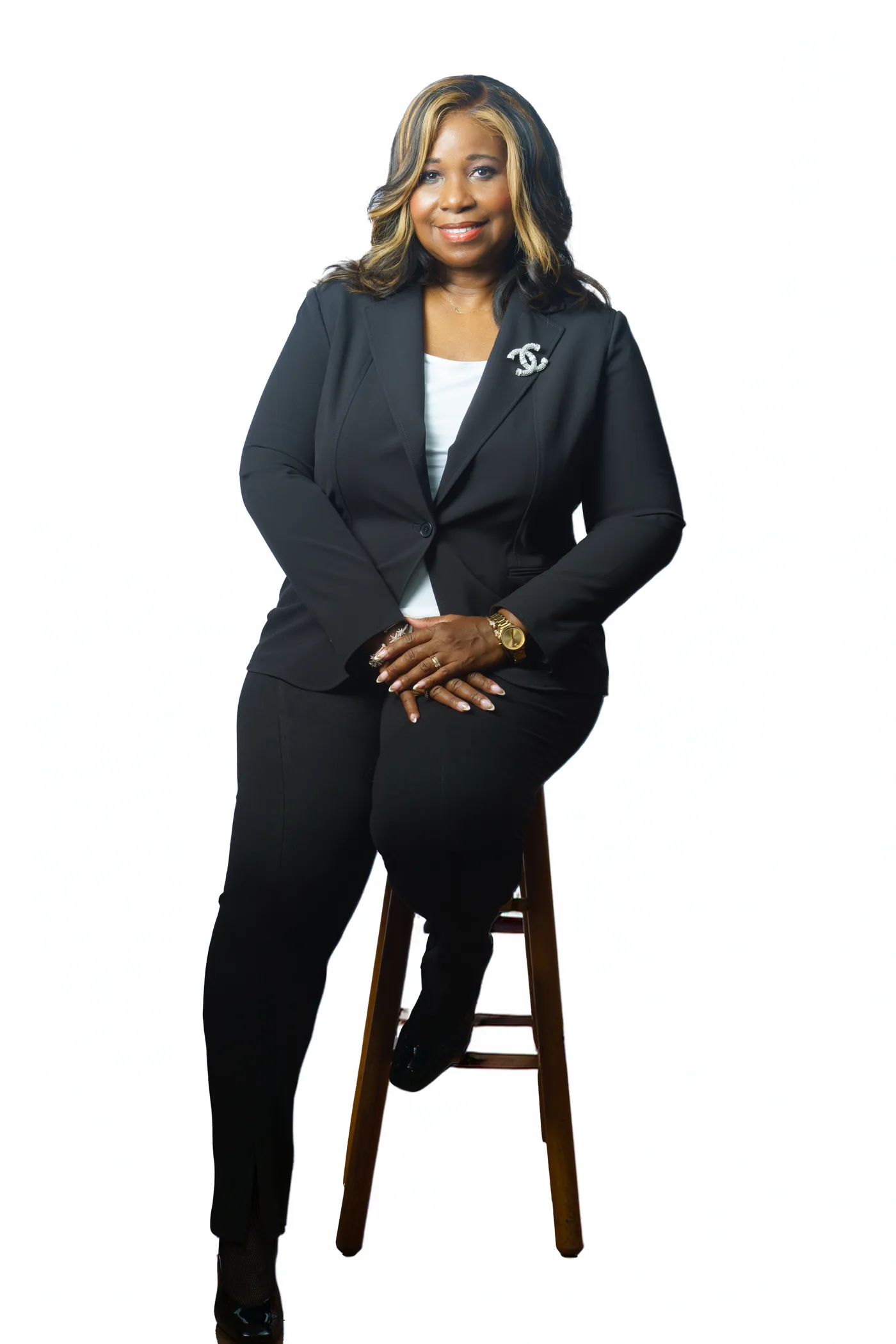 Ellen Coward in a professional suit seated on a stool